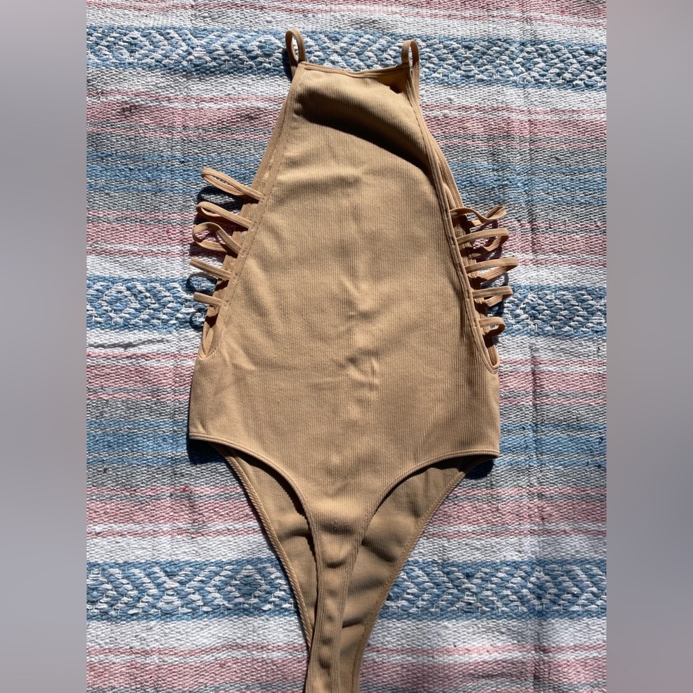 Tan nude bodysuit top with ribbed cutouts on the sides